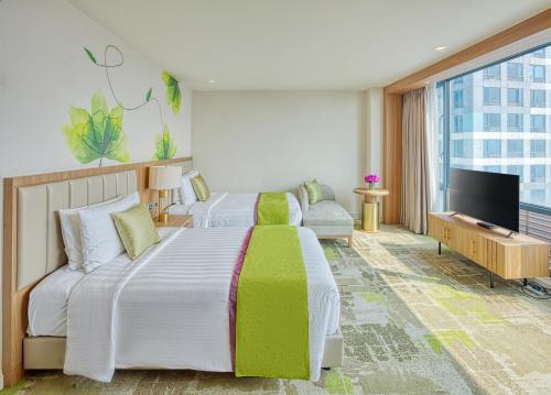 马尼拉Eastwood Richmonde Hotel - Newly Renovated的酒店客房设有两张床和一台平面电视。
