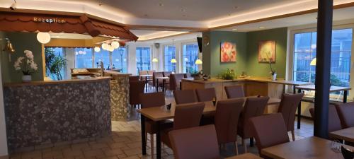 温特贝格祖姆克罗伊茨贝格酒店的餐厅设有桌椅和窗户。