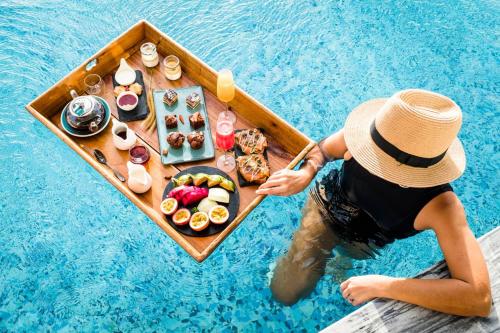 哈拉奇Alia Luxury Suites and Spa的船上的人在游泳池里吃着食物