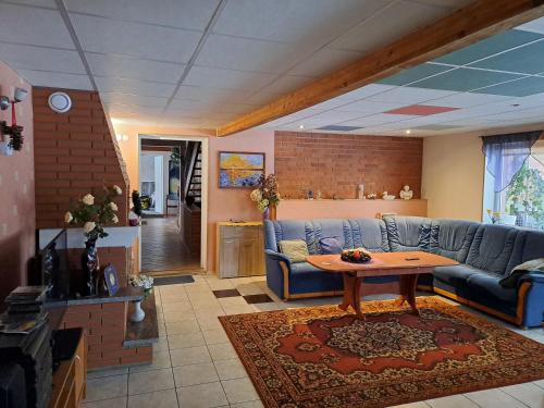 珀尔瓦拉妮玛雅民宿的客厅配有蓝色的沙发和桌子