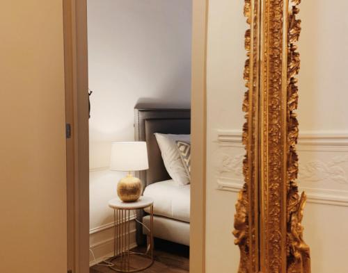 根特La Lys Rooms & Suites的卧室前的镜子,卧室配有一张床