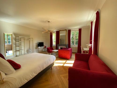 蓬塔穆松Logis HOTEL DU PARC的一间卧室配有一张床和一张红色的沙发