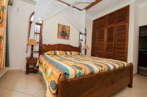 迪亚尼海滩Diani Pearl的一间设有床铺的卧室,位于带窗户的房间内