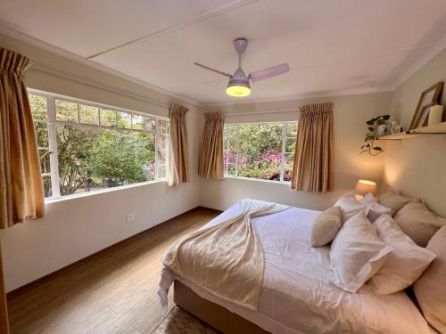 温特顿Berg Escape Bottlebrush - Spacious Luxury Family Home的一间卧室设有一张床和两个窗户。