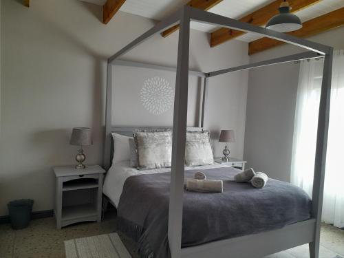 兰格班Camelot Cottages的一间卧室配有一张带两张桌子的大天蓬床