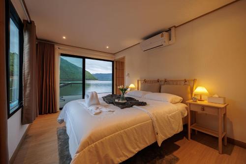 Ban Wang Khun KnachenLakeation kanchanaburi的一间卧室设有两张床和大窗户