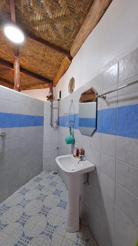 曼巴豪Camiguin Romantic Luxury Stonehouse on Eco-Farm at 700masl的浴室设有水槽和蓝色及白色瓷砖