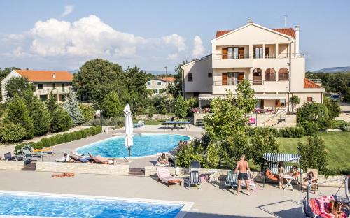 Drinovci斯凯林旅馆的游泳池的景色,那里有人躺在椅子上