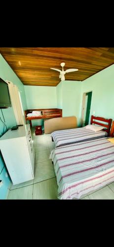 阿拉亚尔-杜卡布Casa de Temporada Arraial do cabo的一间卧室配有两张床和一台平面电视