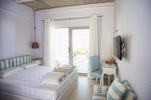 PetresArtemis Seafront Apartments的卧室配有床、椅子和窗户。