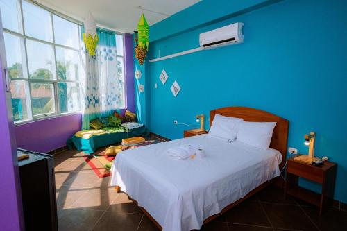 普卡尔帕HOTEL RAYMONDI的蓝色的卧室,配有床和蓝色的墙壁