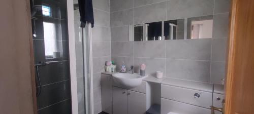 KinghornKINGHORN - Private room, ensuite & sunroom with Fab views的白色的浴室设有水槽和淋浴。