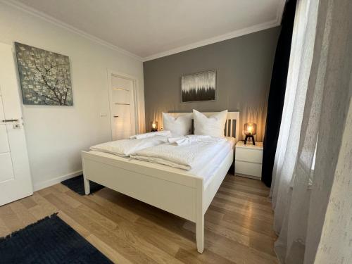 格拉130m² Designerwohnung mit 2 Vollbädern的一间卧室配有带白色床单和枕头的床。