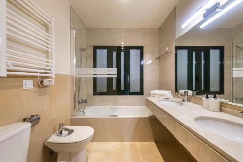 弗安特阿拉莫El Oasis Casa Palmera 16 Bajo B的浴室配有卫生间、浴缸和水槽。