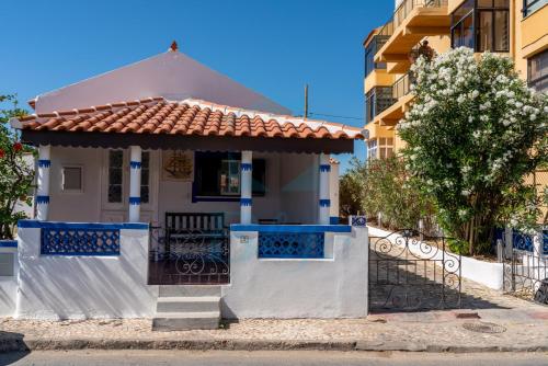 法鲁BLife Faro Beach Hostel的白色的房子,有门和栅栏