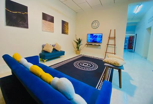 珍南海滩SOFEA HOMESTAY的客厅配有蓝色的沙发和电视