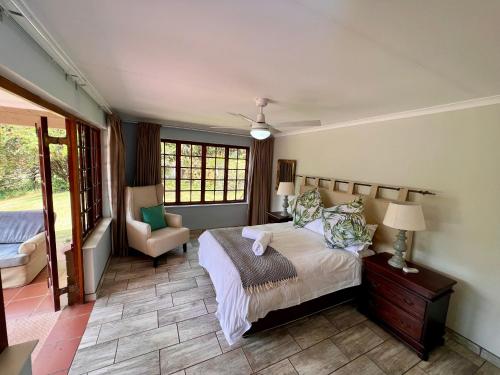 温特顿Berg Escape Kiepersol - Spacious Luxury Family Home的一间卧室配有一张床和一把椅子