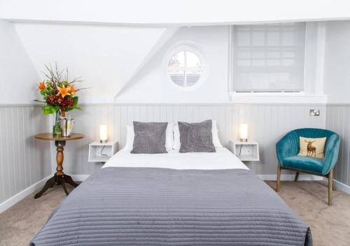 萨顿科尔菲尔德The Townhouse Sutton的一间卧室配有一张大床和一张蓝色椅子