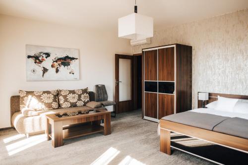 顺佩尔克优雅酒店的一间卧室配有一张床、一张沙发和一张桌子