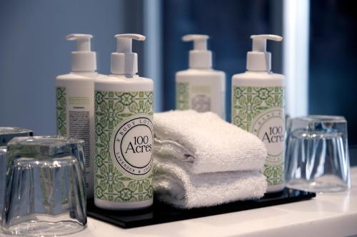 巴斯Francis Hotel Bath的柜台上四瓶肥皂和毛巾