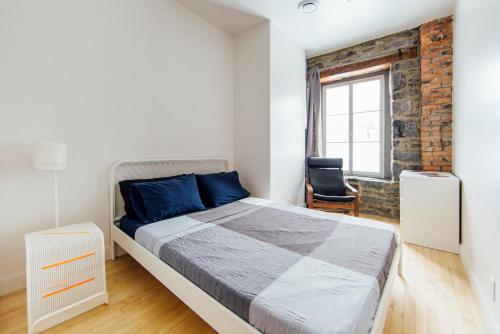 蒙特利尔Alt Hostel的一间卧室设有一张床和砖墙