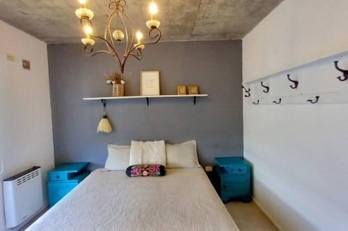蒂格雷Moderno dpto cercanías Puerto de Frutos!的一间卧室配有一张床和一个吊灯