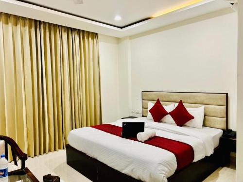 齐拉克普尔Stay @Northview park hotel zirakpur的一间卧室配有一张带红色枕头的大床