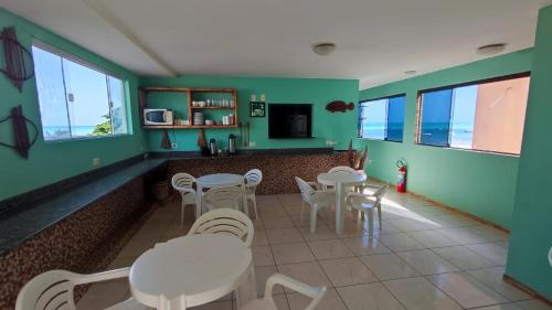 马拉戈日Fabika Pousada的餐厅拥有绿色的墙壁和白色的桌椅
