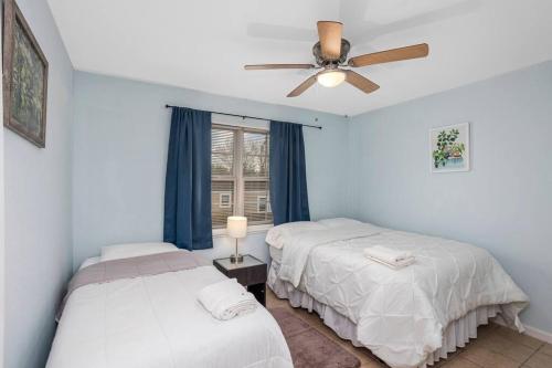 IowaQuiet apartment in Iowa, LA的一间卧室配有两张床和吊扇