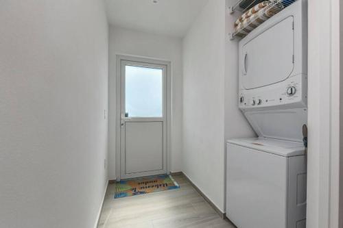 奥拉涅斯塔德Commandeurs Apartments unit 4D的一间白色的房间,设有门、洗衣机和烘干机
