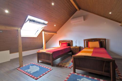 法蒂玛Solar das Estrelas的阁楼卧室设有两张床和天窗