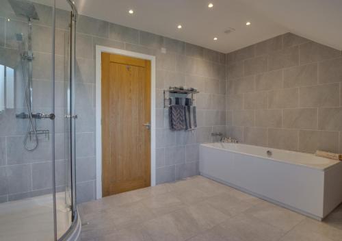 CoelbrenBreconview Lodge的带浴缸和玻璃淋浴间的浴室。