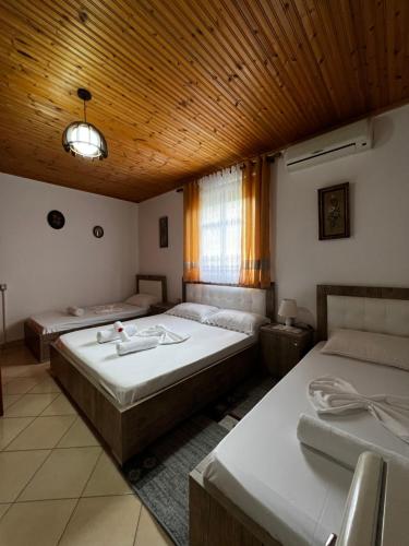 培拉特Guesthouse Emiljano的一间卧室设有两张床和木制天花板