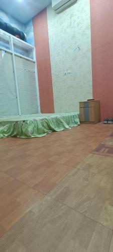 WenditHouse of Nadifsa的一间空房间,地板上铺着绿床单