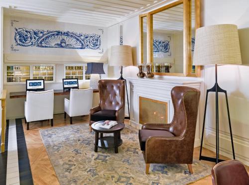 里斯本H10杜克德楼尔酒店的客厅配有椅子和壁炉