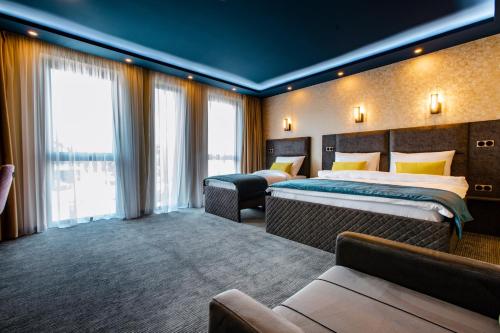 比哈奇HOTEL LOBBY的酒店客房,设有两张床和一张沙发