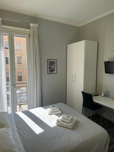 罗马The Manzoni的一间卧室配有一张床、一张书桌和一个窗户。