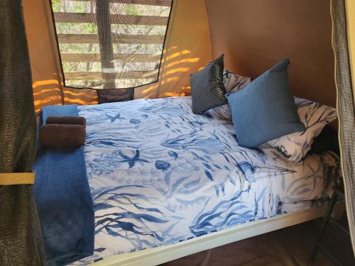 SkeerpoortHideout River View Tent的一张带蓝色和白色床单及枕头的床