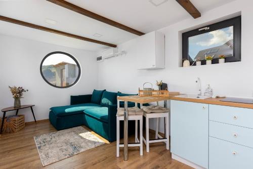 锡尔内亚Zen Nest Tiny House的客厅配有蓝色的沙发和桌子