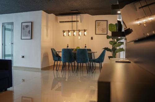 莱维顿North Breeze Guest House的一间带桌子和蓝色椅子的用餐室