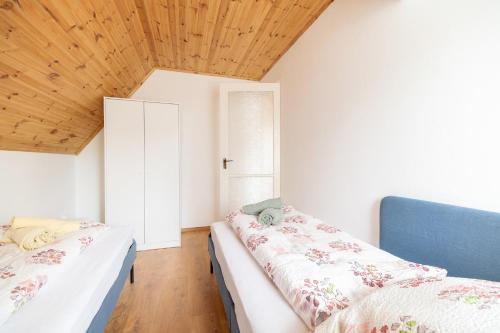 泽拜盖尼BoRóza Vendégház的一间卧室设有两张床和木制天花板