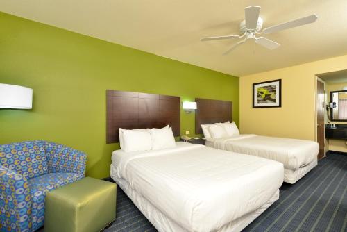 针城品质酒店 - 针城的酒店客房,配有两张床和椅子