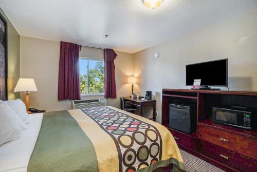 芒特普莱森特宜人山速8酒店的配有一张床和一台平面电视的酒店客房