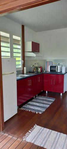 GuenouilletKaz'a fred的厨房配有红色橱柜和白色冰箱