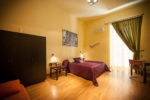科拉托Albergo Tripoli B&B Affittacamere的一间卧室配有一张床,并在一间客房内配有电视。