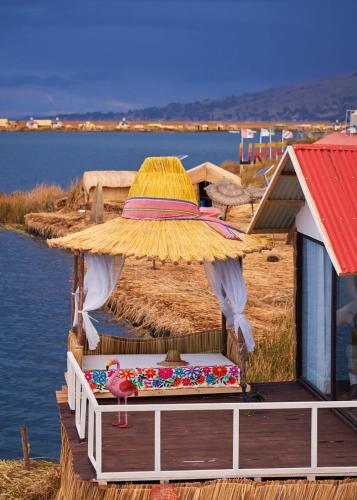 普诺Mojsa titicaca lodge的水边码头上的大伞