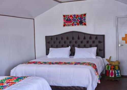 普诺Mojsa titicaca lodge的一间卧室配有一张大床和大床头板