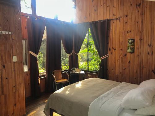 蒙泰韦尔德哥斯达黎加YerbaBuena Modern Stay in the Cloud Forest的一间卧室配有床和带窗帘的窗户