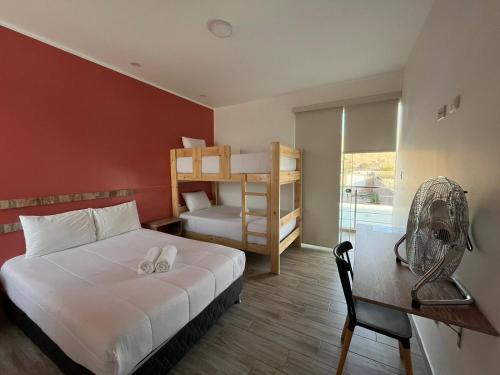 伊察La Estancia Hotel Ica的一间卧室配有一张床、一张桌子和一张双层床。