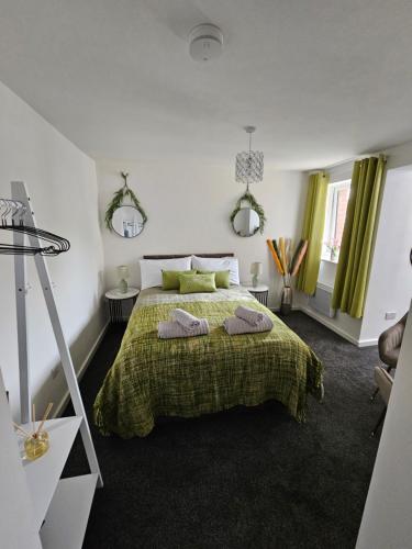 斯蒂夫尼奇Luxury Studio Stevenage的一间卧室配有绿床和两个枕头